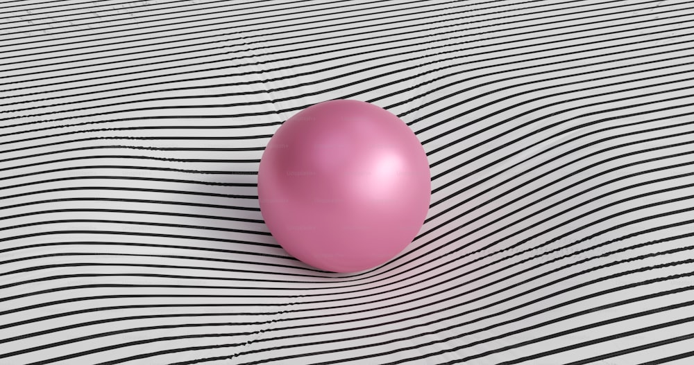 a pink balloon sitting on top of a black and white striped surface