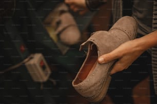 a person holding a pair of shoes in their hand