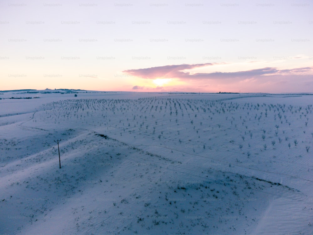 a field covered in snow under a cloudy sky