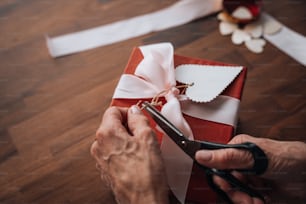 a person cutting a ribbon with a pair of scissors