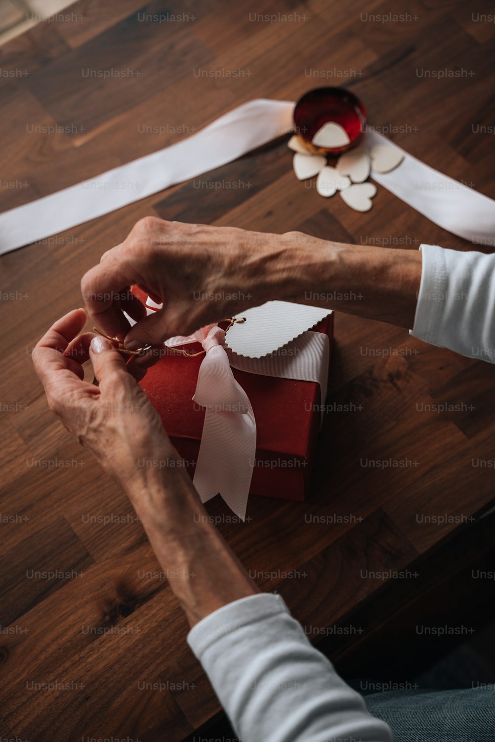 a woman is wrapping a red and white present
