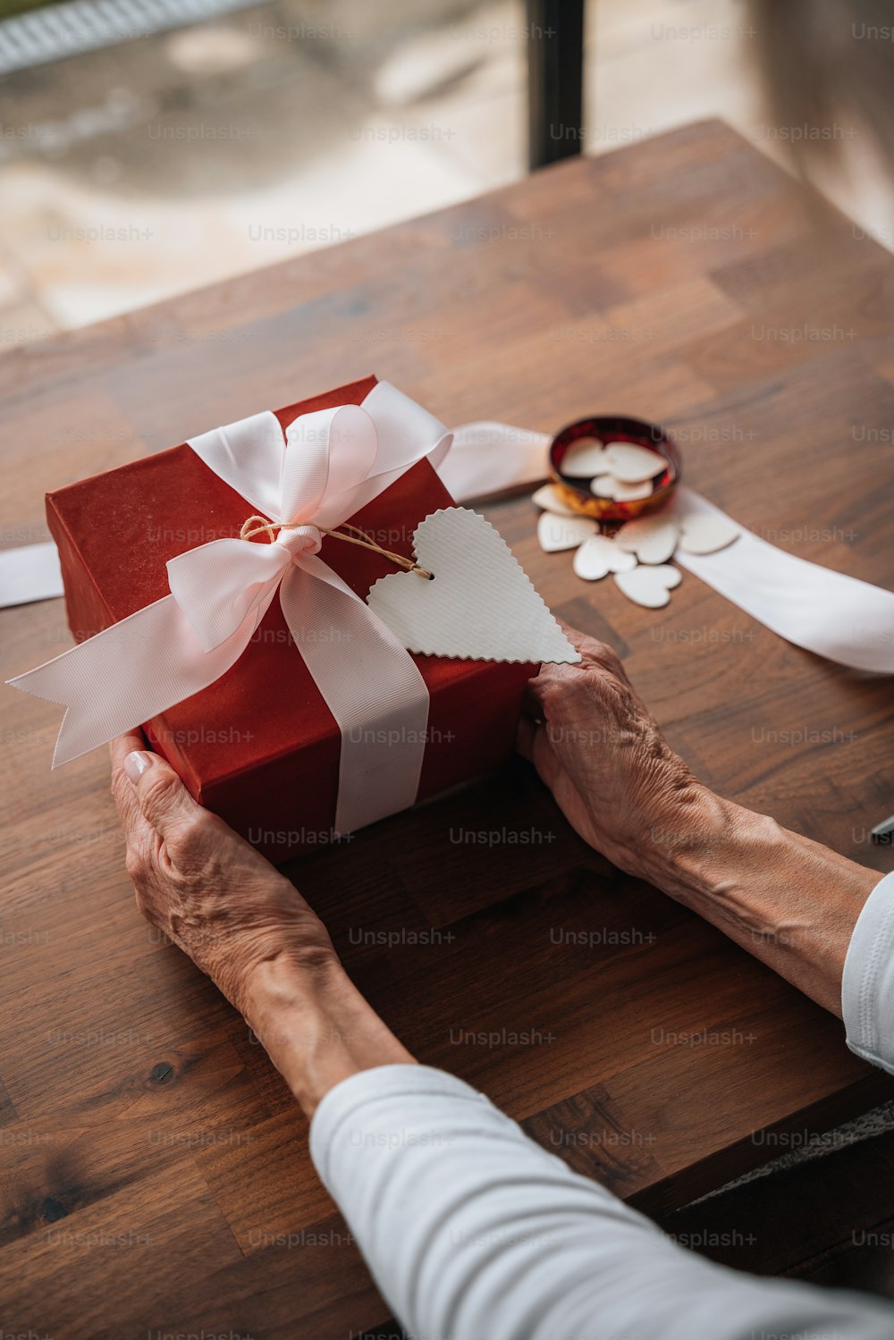 a person holding a red and white gift box