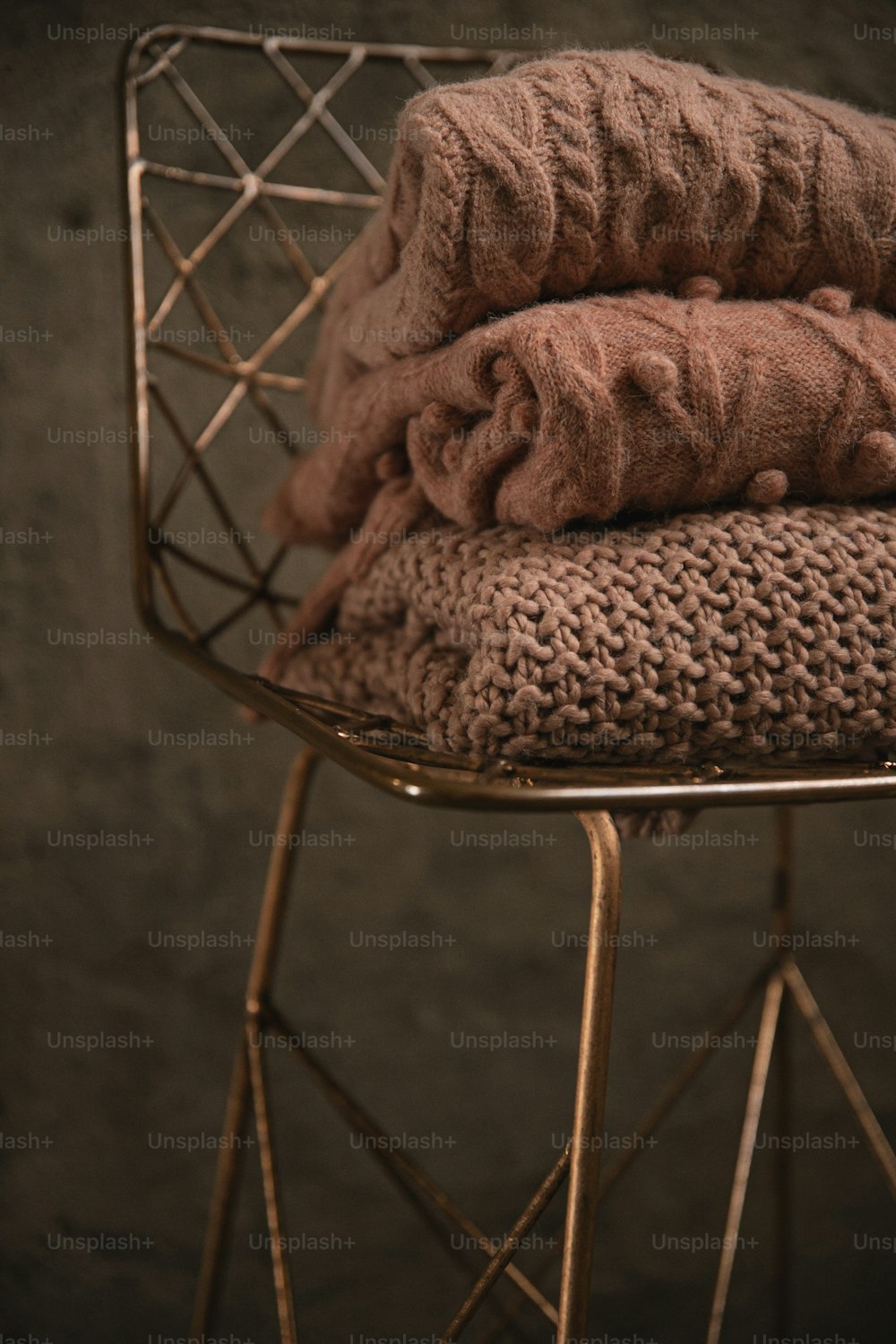 a stack of blankets sitting on top of a metal chair