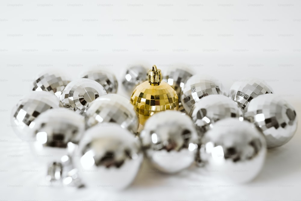 a bunch of shiny silver balls on a white surface
