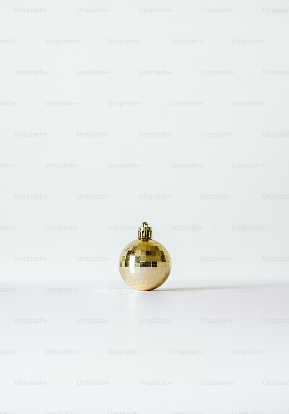 Un jarrón de oro sentado encima de una mesa blanca