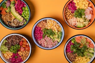 four bowls of different types of food on a yellow surface