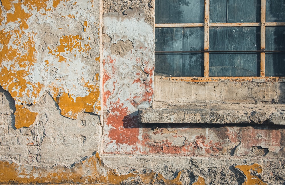 an old building with a window and peeling paint