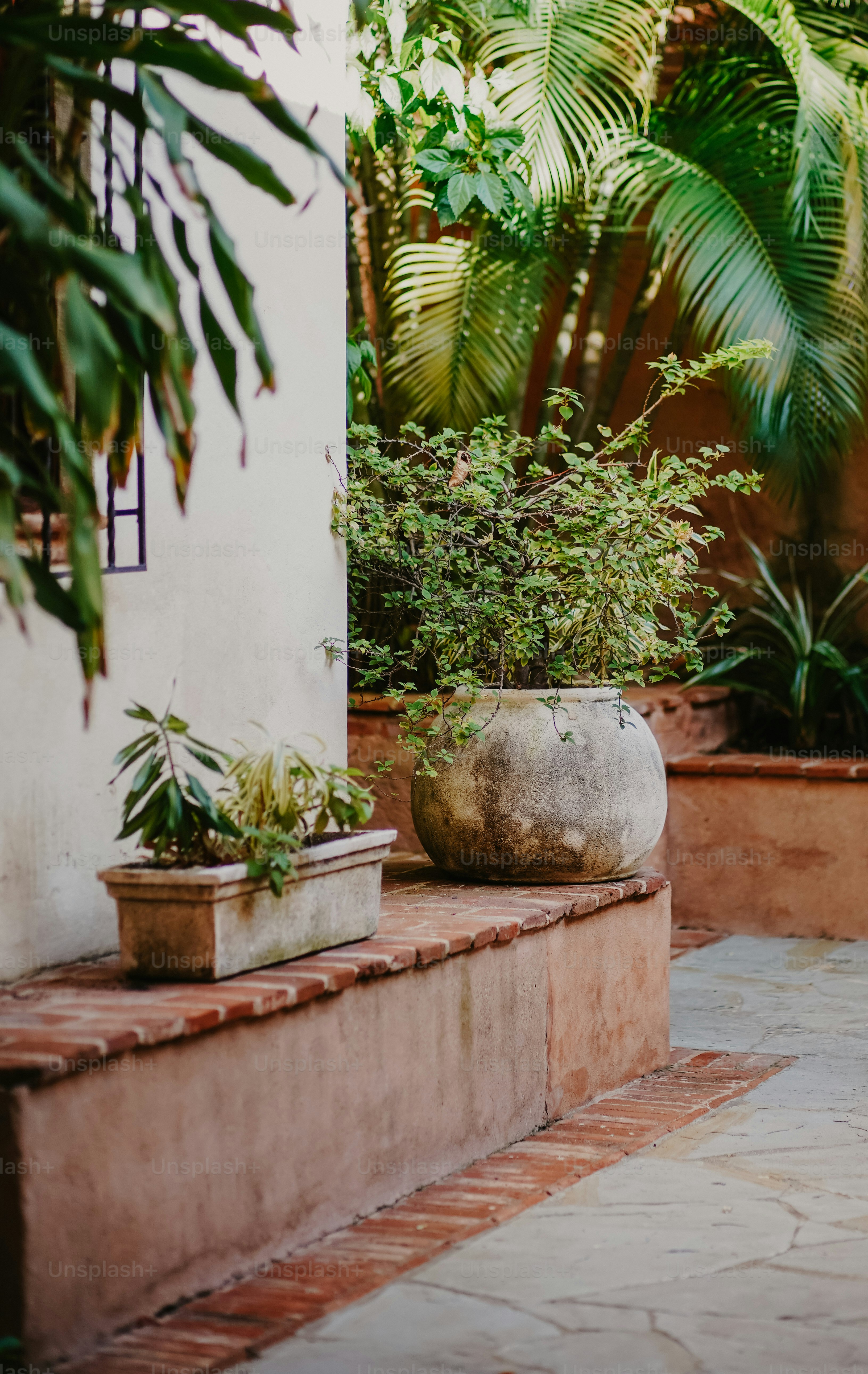 a couple of planters sitting on top of a stone bench