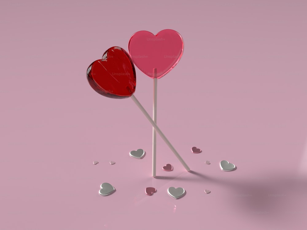 dois pirulitos em forma de coração em um fundo rosa