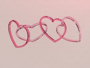 a couple of pink hearts hanging from a string