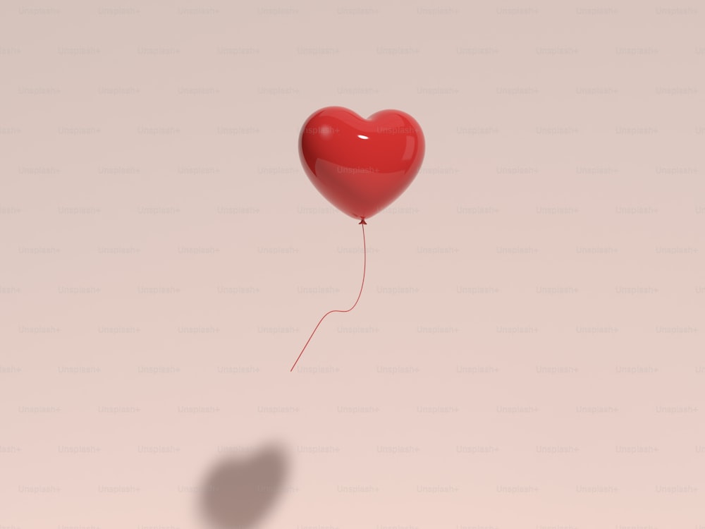 a red heart shaped balloon floating in the air