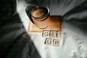 a cup of coffee sitting on top of a wooden coaster