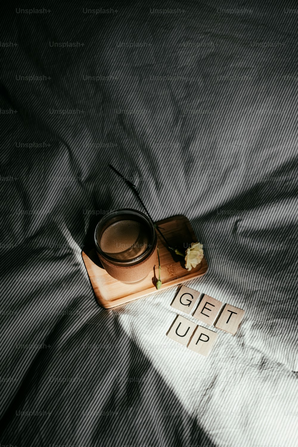 a wooden box with a flower on top of a bed