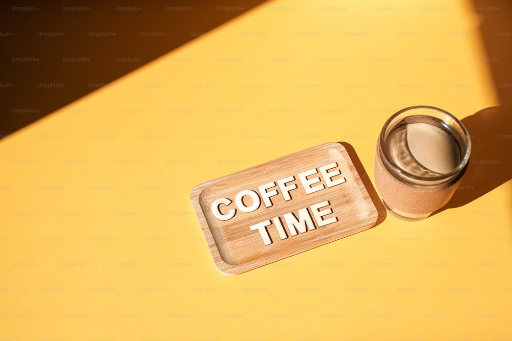 a cup of coffee next to a sign that says coffee time