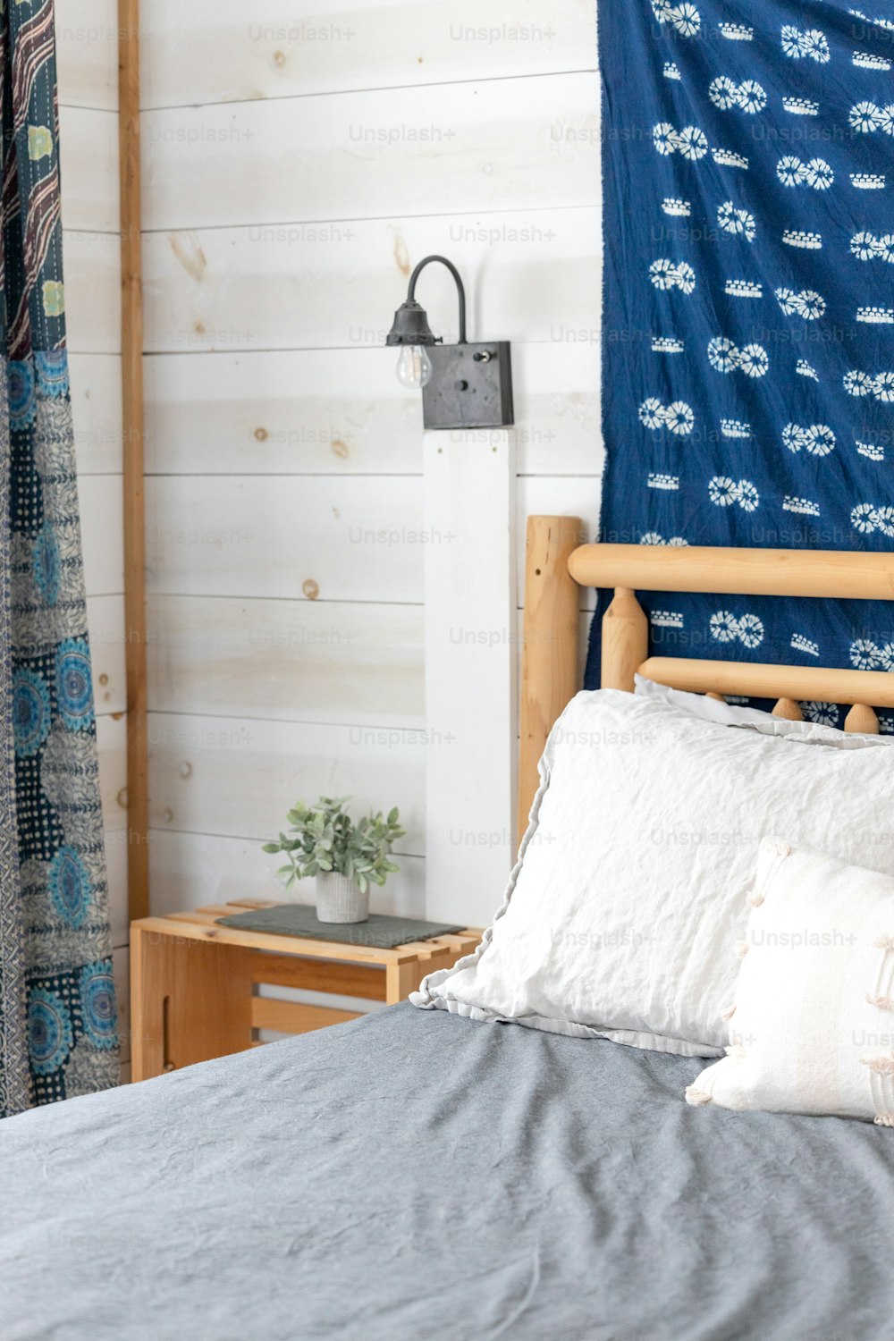 uma cama com um cobertor azul e travesseiros