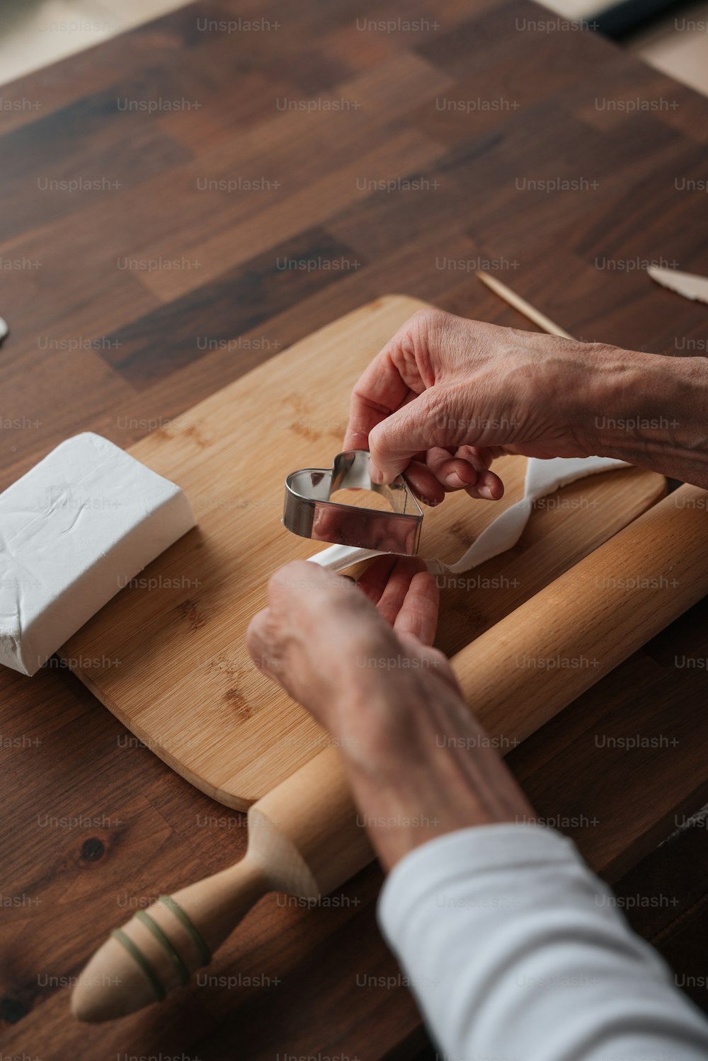 Una persona cortando un trozo de madera con un par de tijeras