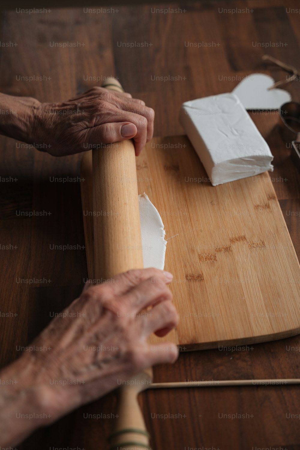 a person rolling up a piece of wood with a rolling pin