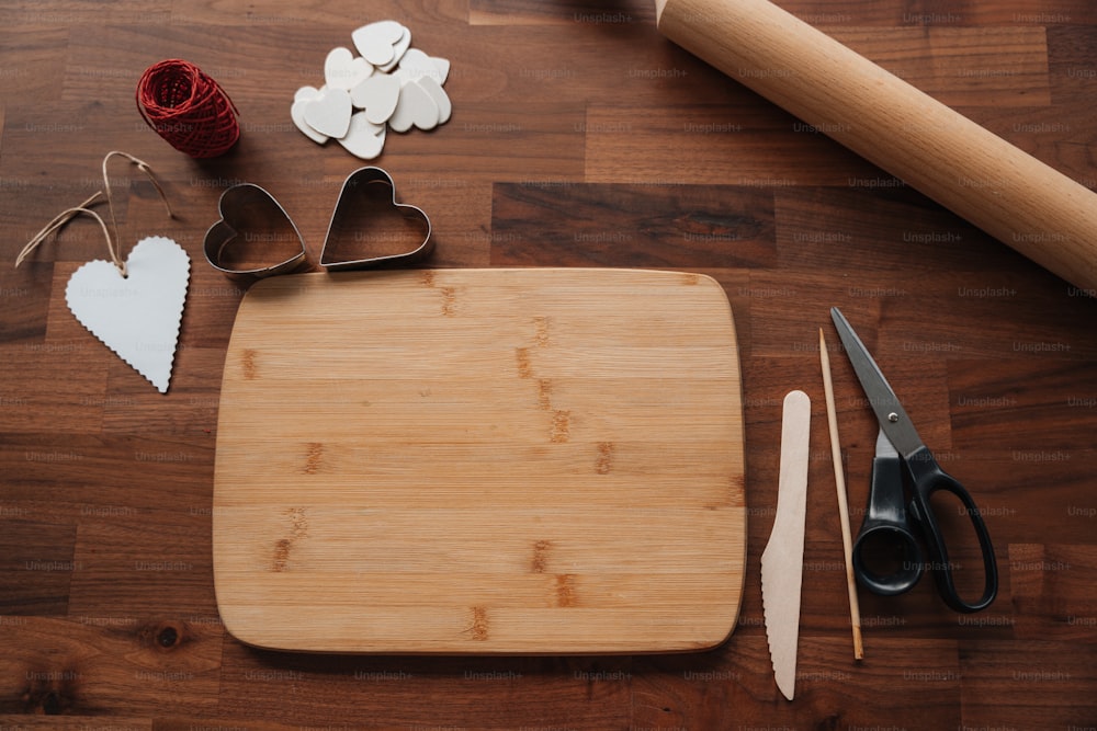 a cutting board with hearts, scissors, and other crafting supplies