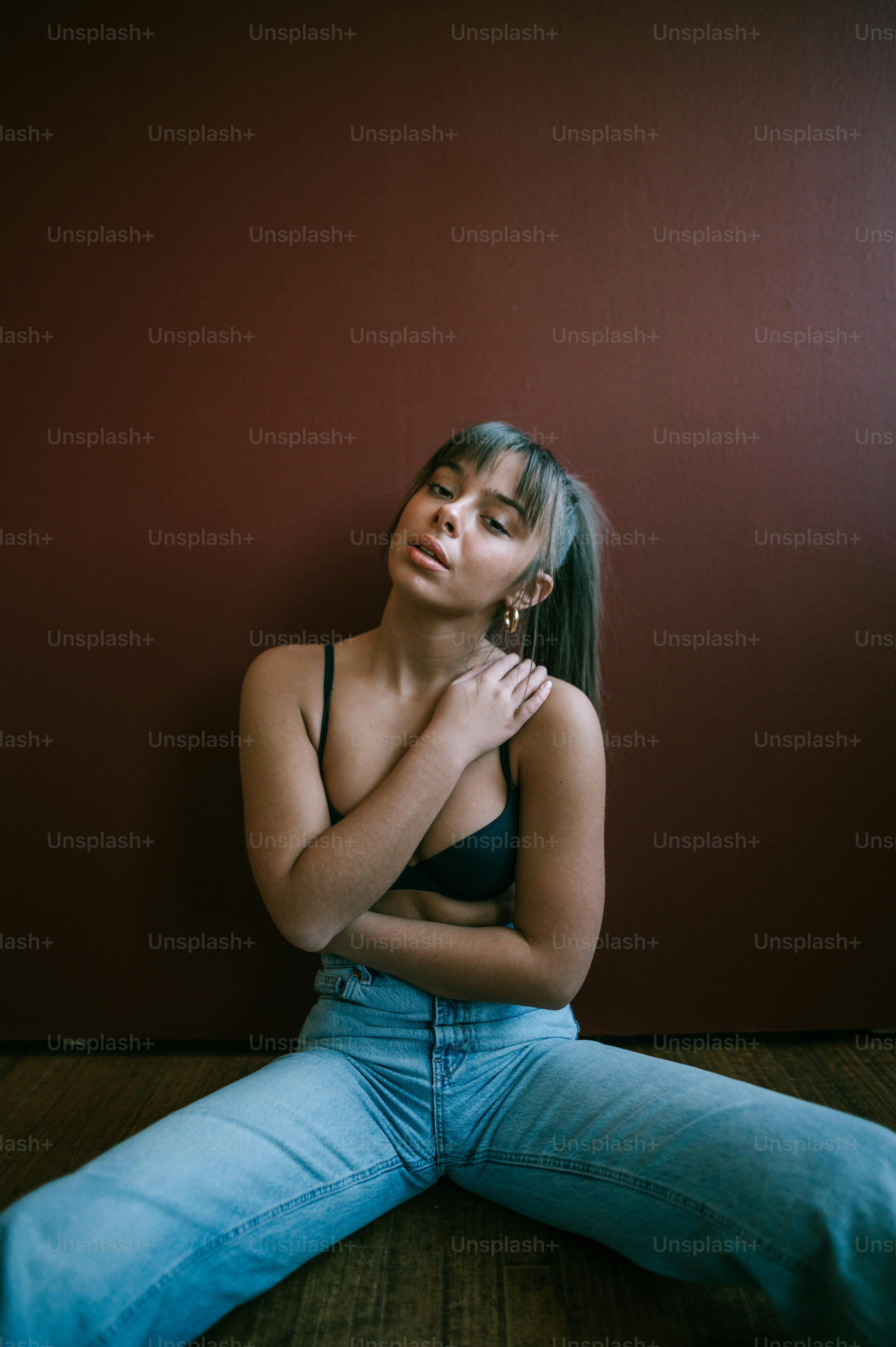 腕を組んで床に座っている女性