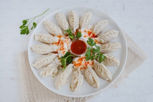 a white plate topped with dumplings covered in sauce