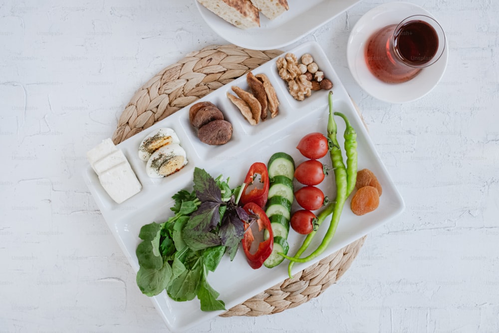 a platter of vegetables and meats with a cup of tea