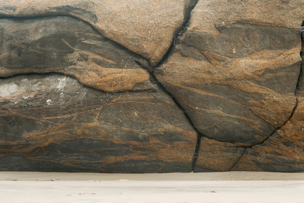 Ein Mann auf einem Surfbrett auf einem großen Felsen