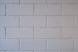 a white brick wall with a red stop sign on it