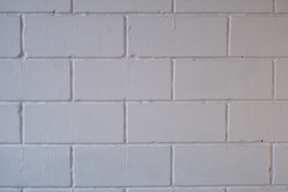 a white brick wall with a red stop sign on it