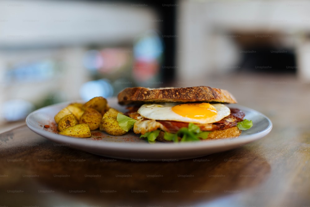 a plate with a sandwich and potatoes on it