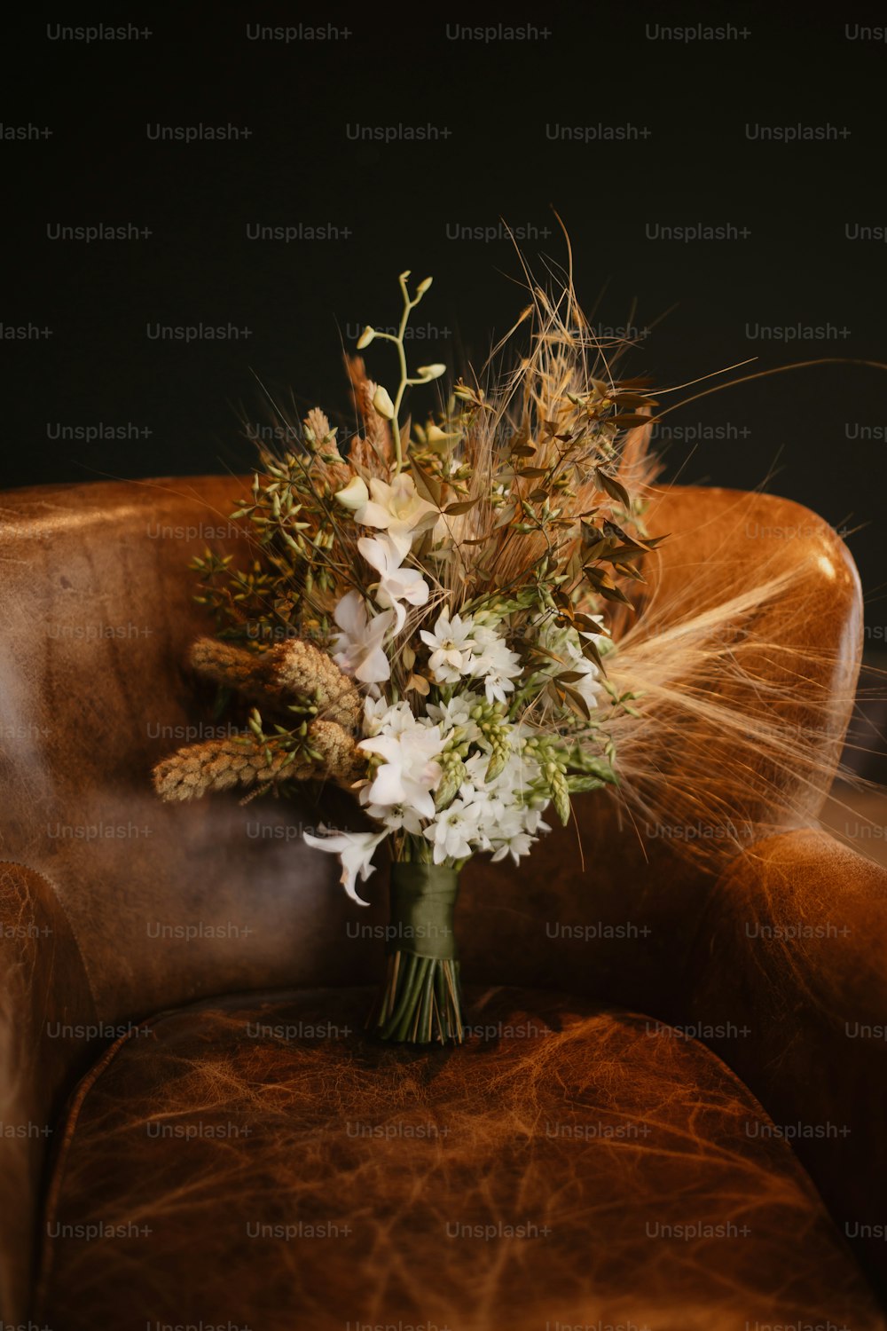 a bouquet of flowers sitting on top of a brown chair