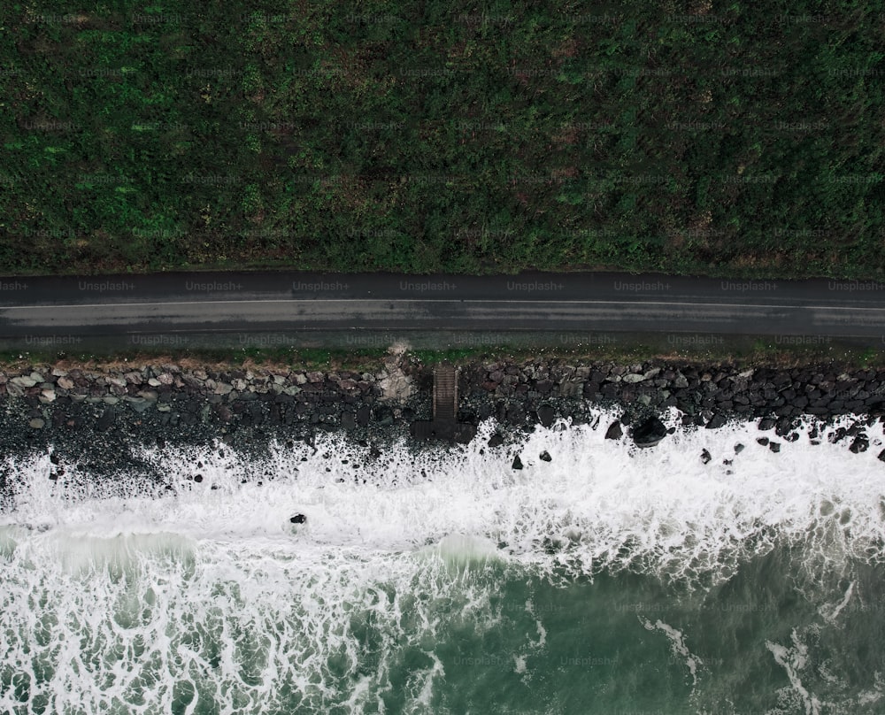 an aerial view of a body of water near a road