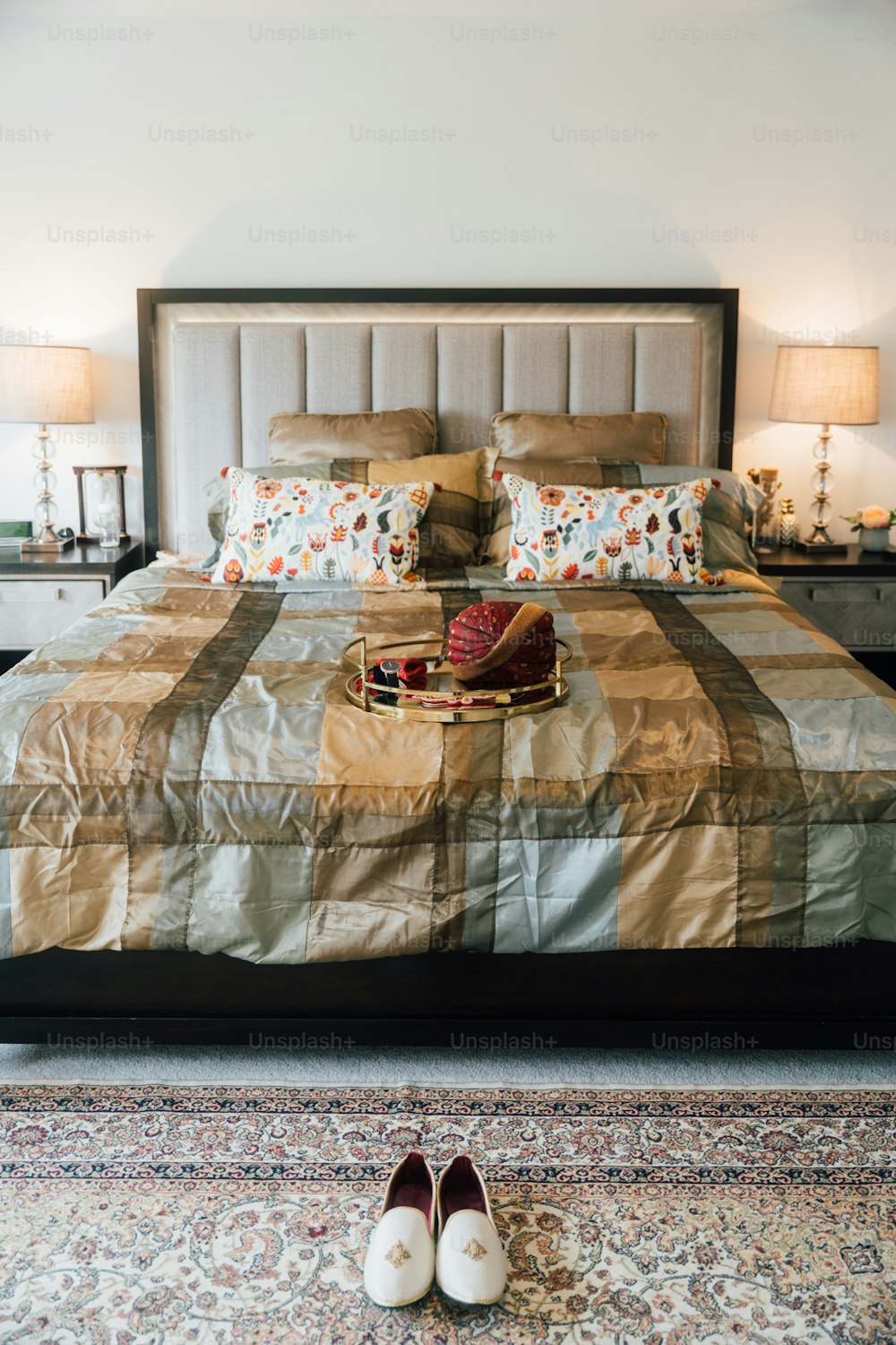 un dormitorio con una cama grande y un par de zapatos en el suelo