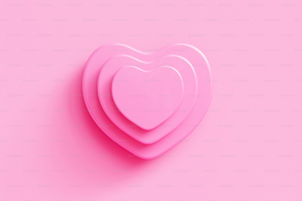 Tre piatti rosa a forma di cuore su uno sfondo rosa