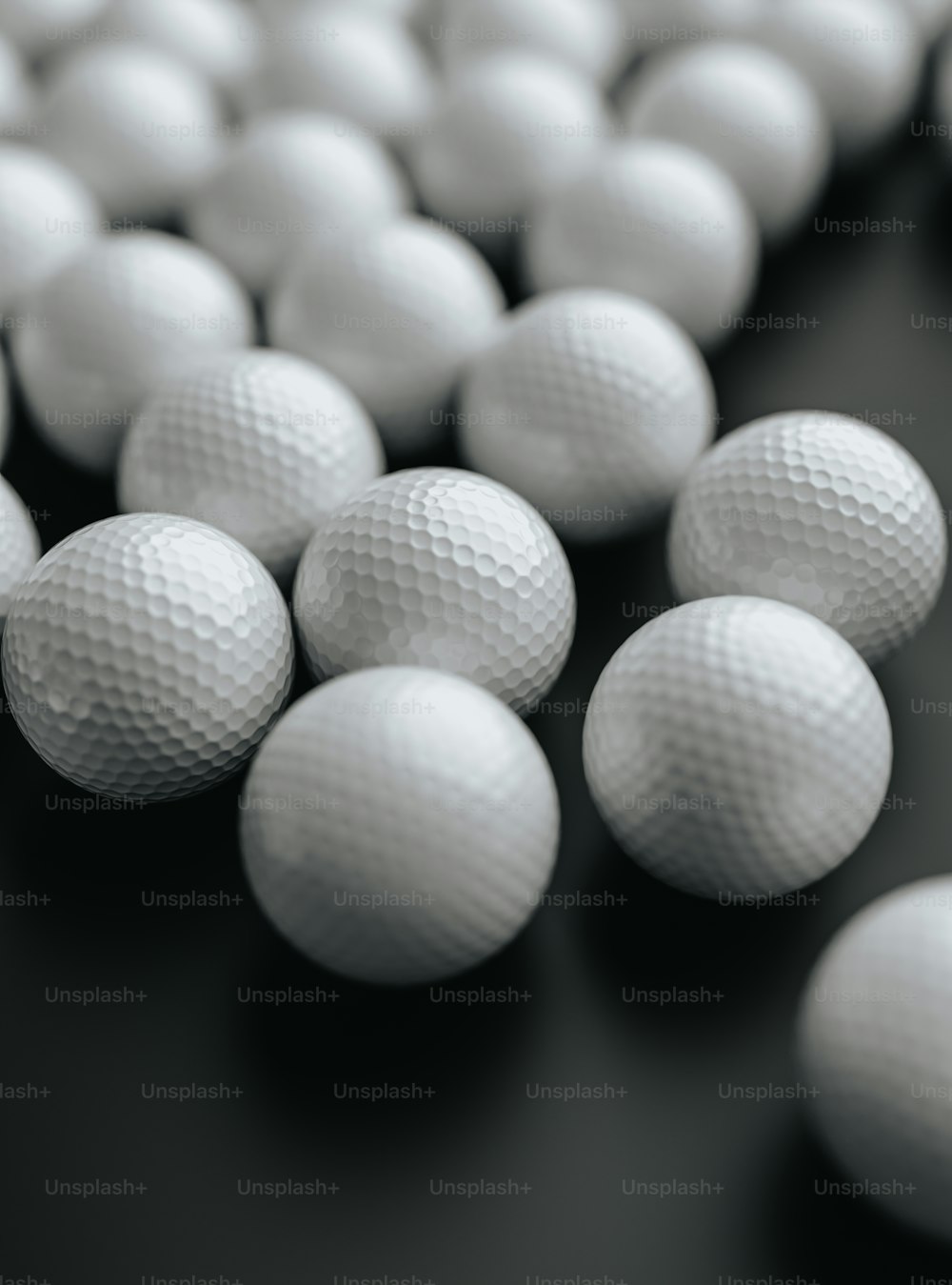 a bunch of white golf balls on a black surface