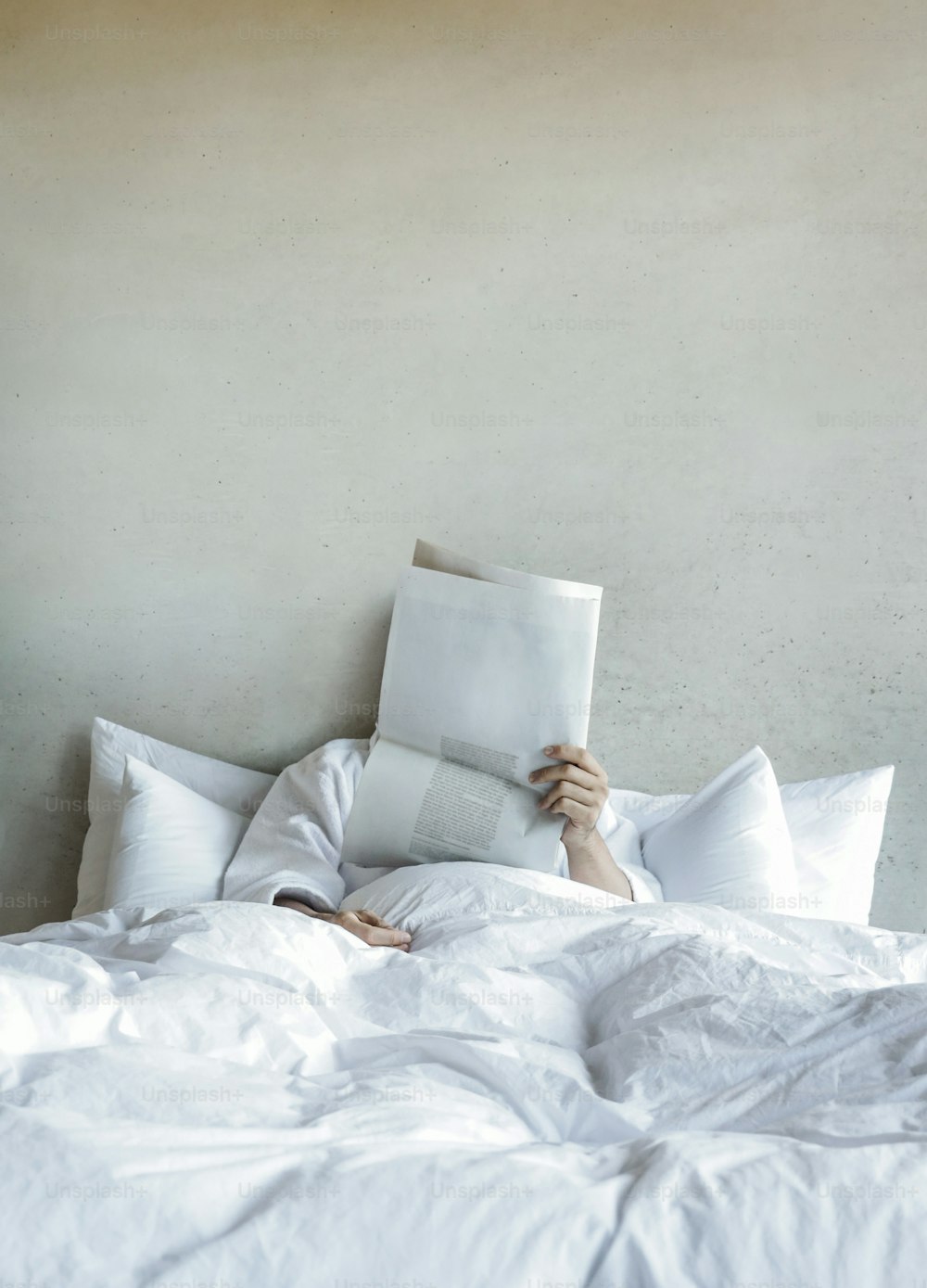 Eine Person, die im Bett liegt und ein Buch liest