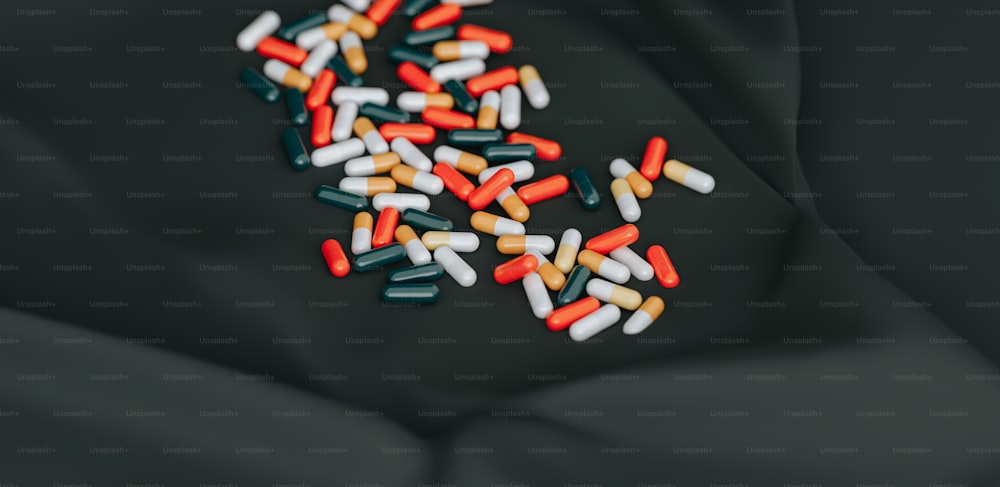 Un montón de píldoras sentadas encima de una superficie negra