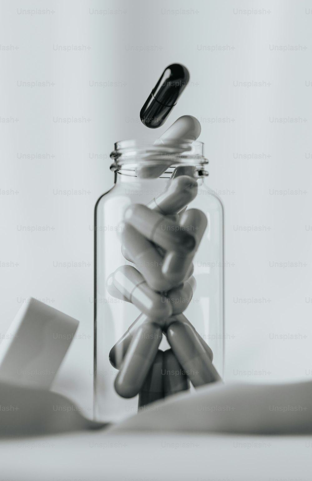Un frasco de vidrio lleno de píldoras encima de una mesa