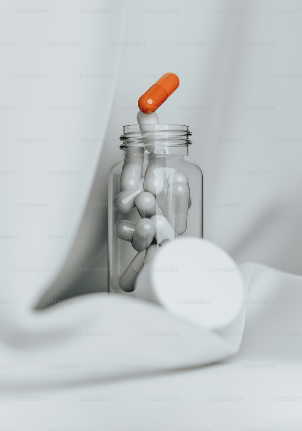 un bocal en verre rempli de pilules à côté d’une cuillère