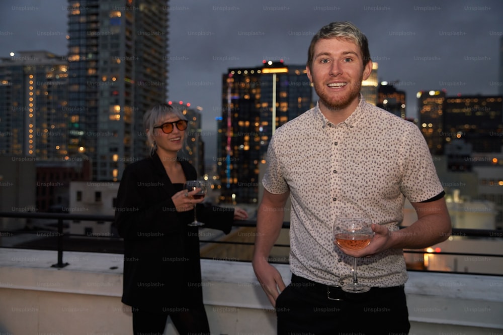 a man and a woman standing on a roof with a city skyline in the background