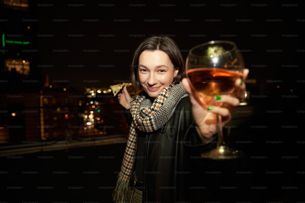uma mulher segurando um copo de vinho em sua mão