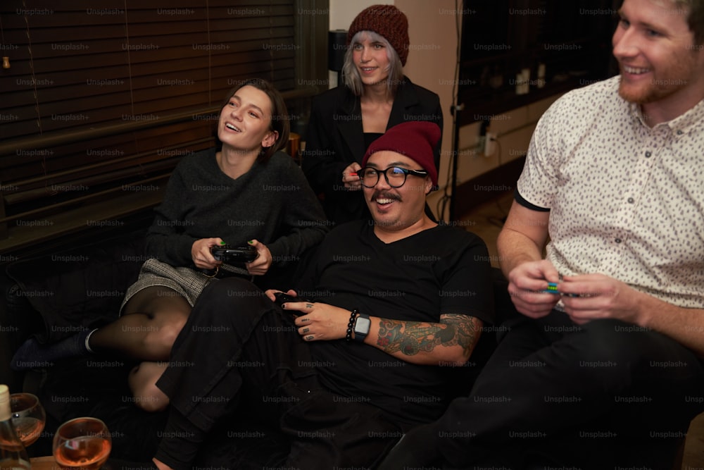 Eine Gruppe von Leuten, die herumsitzen und ein Videospiel spielen