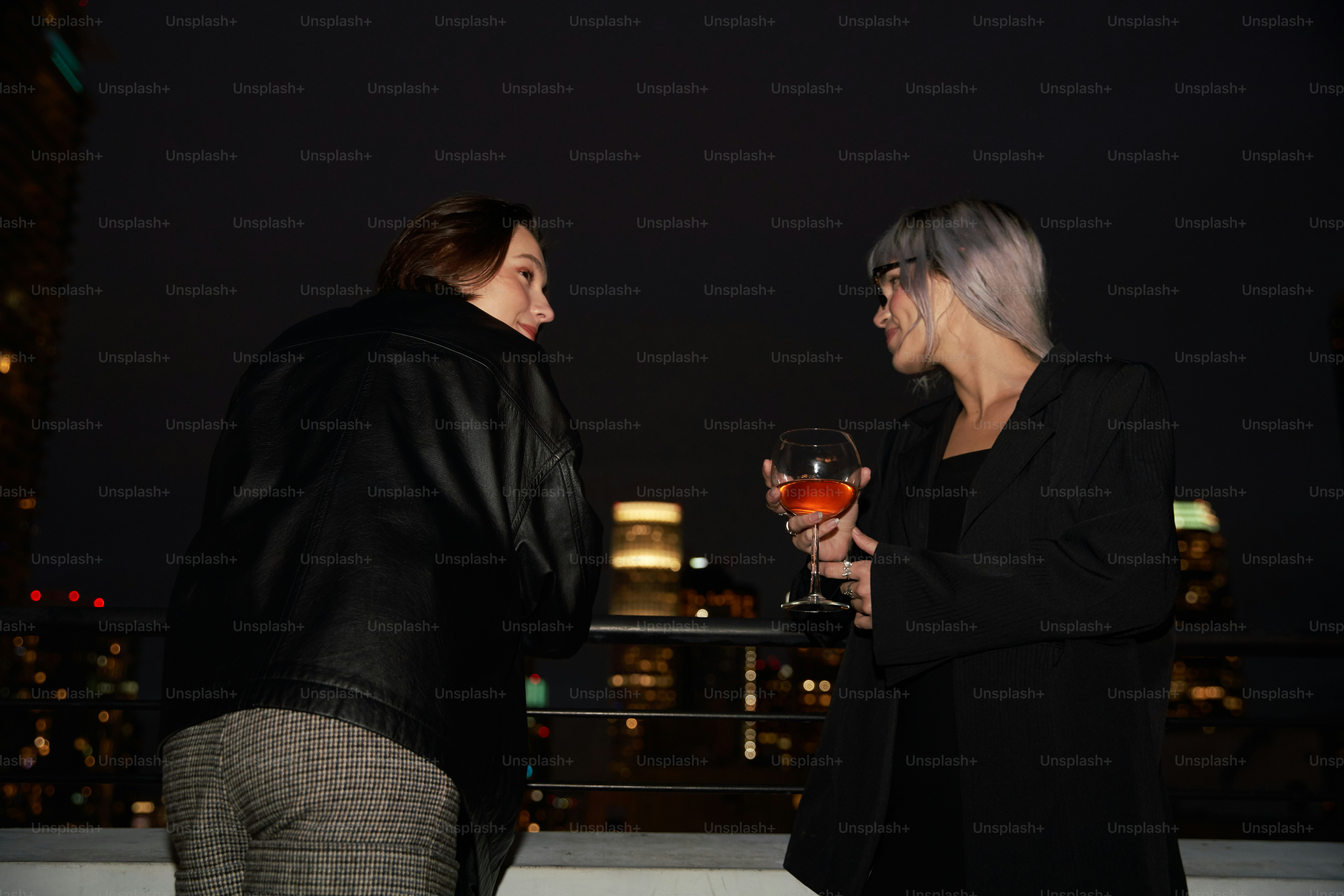 a couple of women standing next to each other holding wine glasses