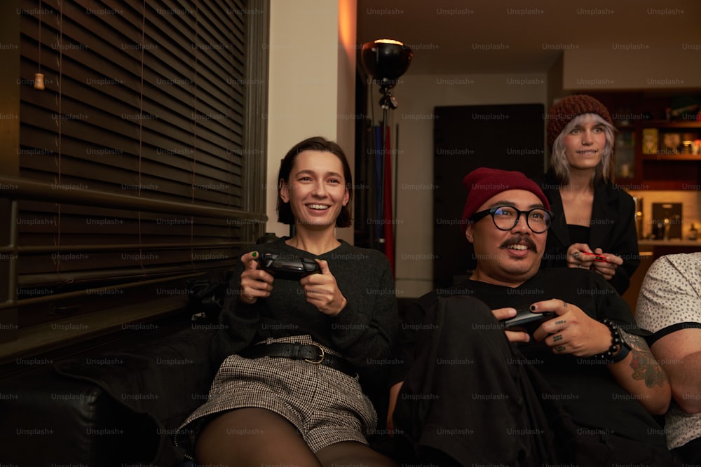 a group of people sitting next to each other holding game controllers
