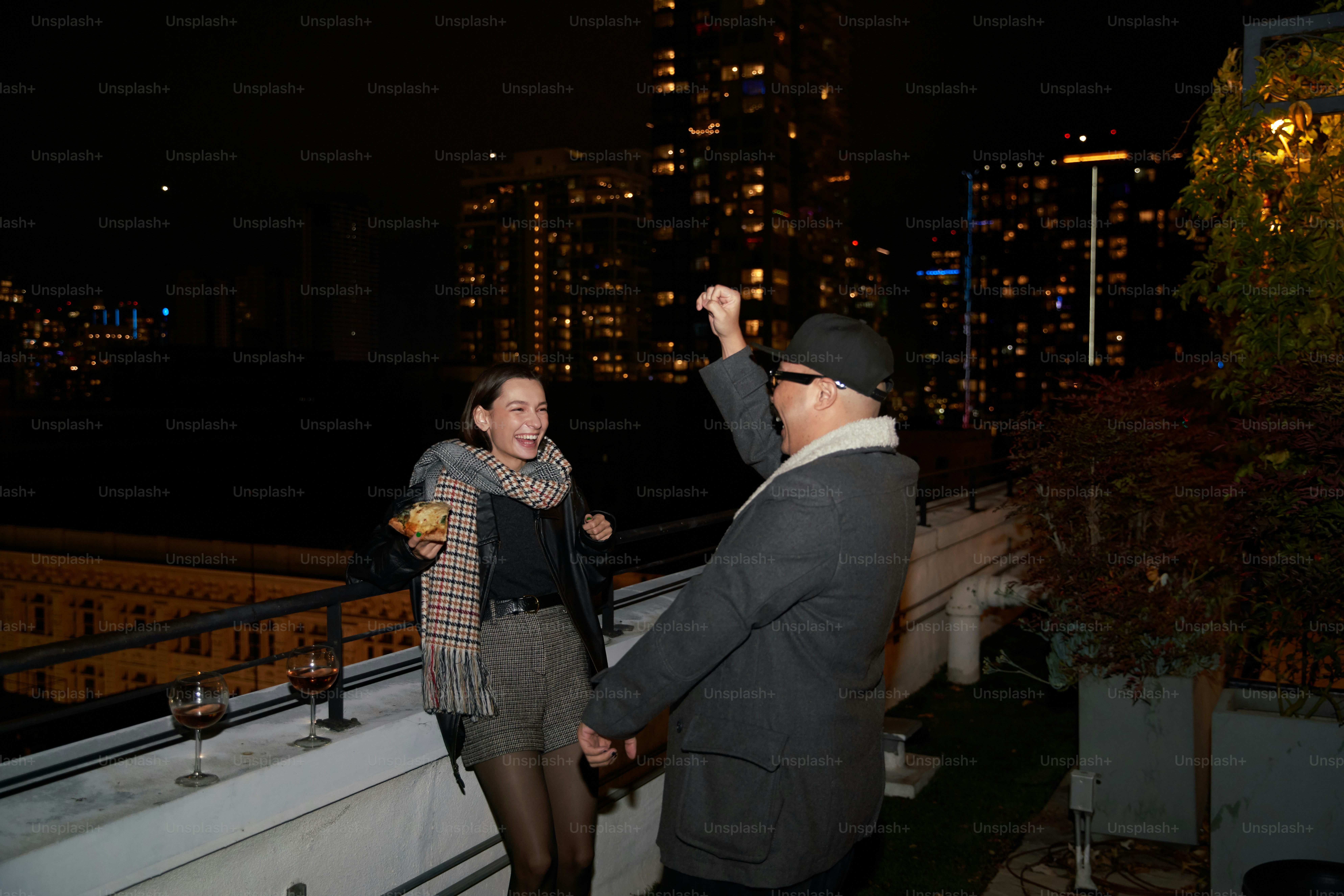 a man standing next to a woman on top of a roof
