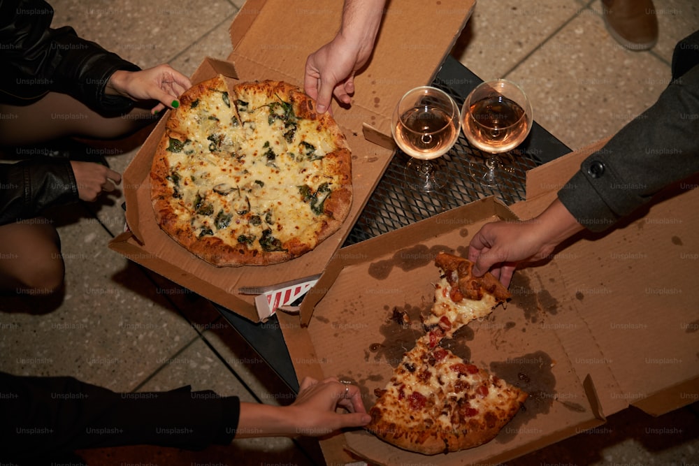 a group of people eating pizza and drinking wine