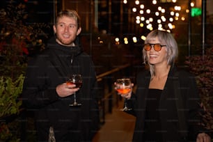 a man and a woman holding wine glasses