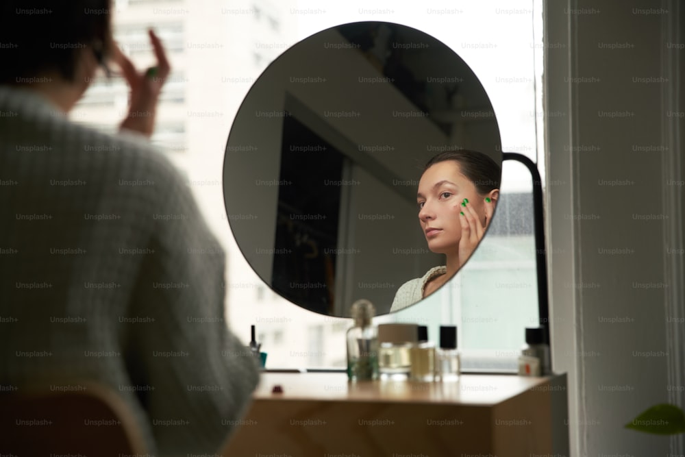 a woman is looking at her reflection in the mirror