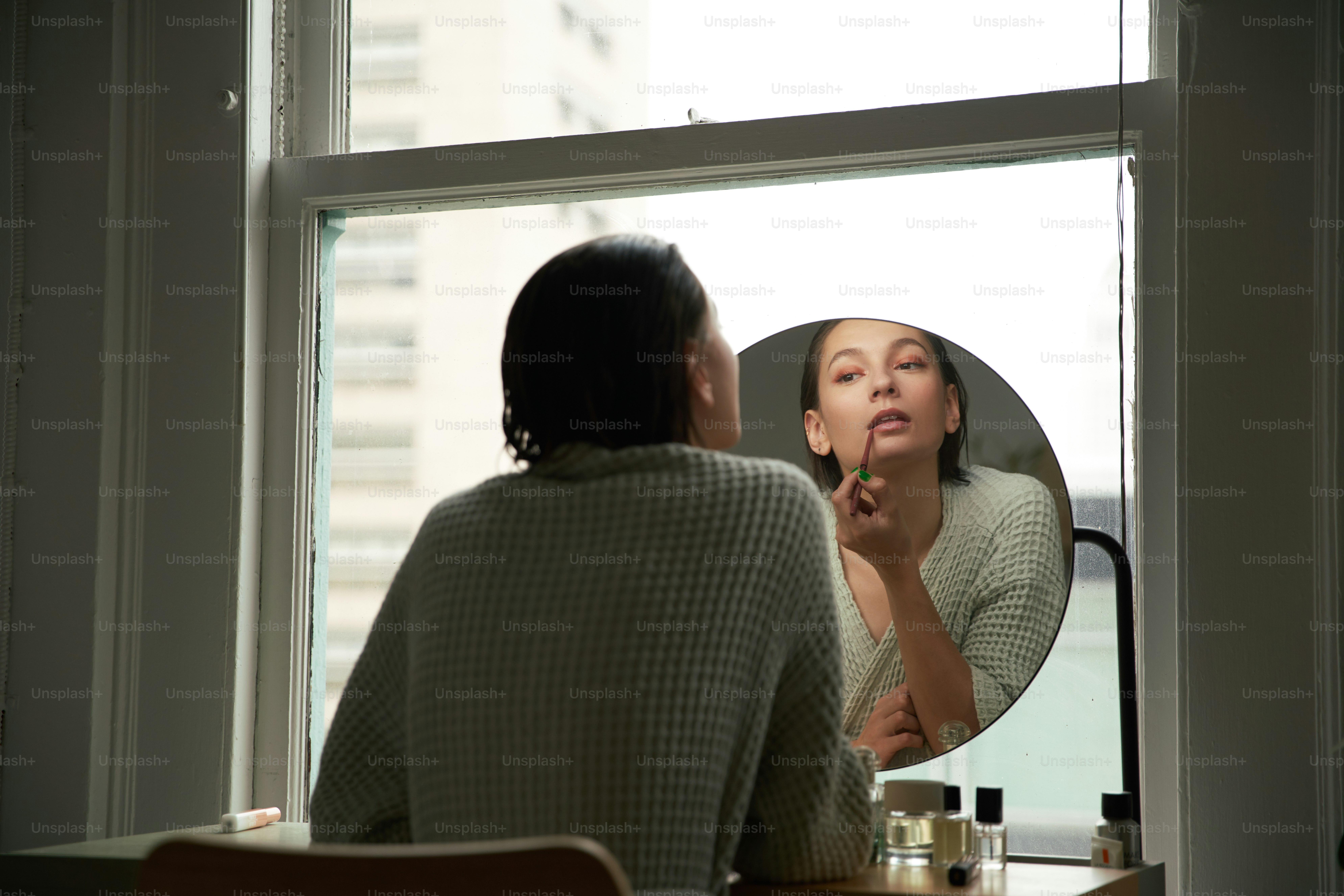 a woman looking at herself in the mirror