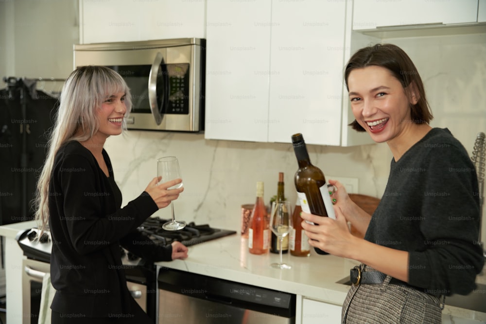 a couple of women standing next to each other in a kitchen