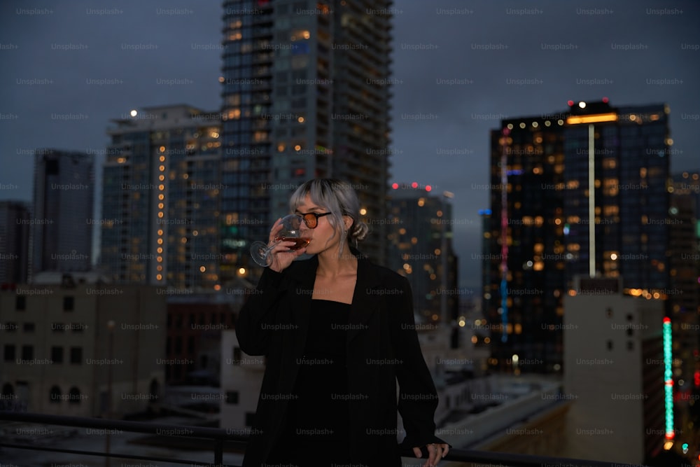 uma mulher em pé em cima de um telhado falando em um telefone celular